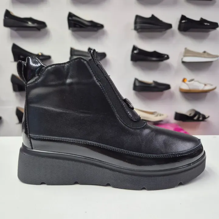 Ghete dama negre cu fermoar si elastic, profil lateral pe fundal cu pantofi